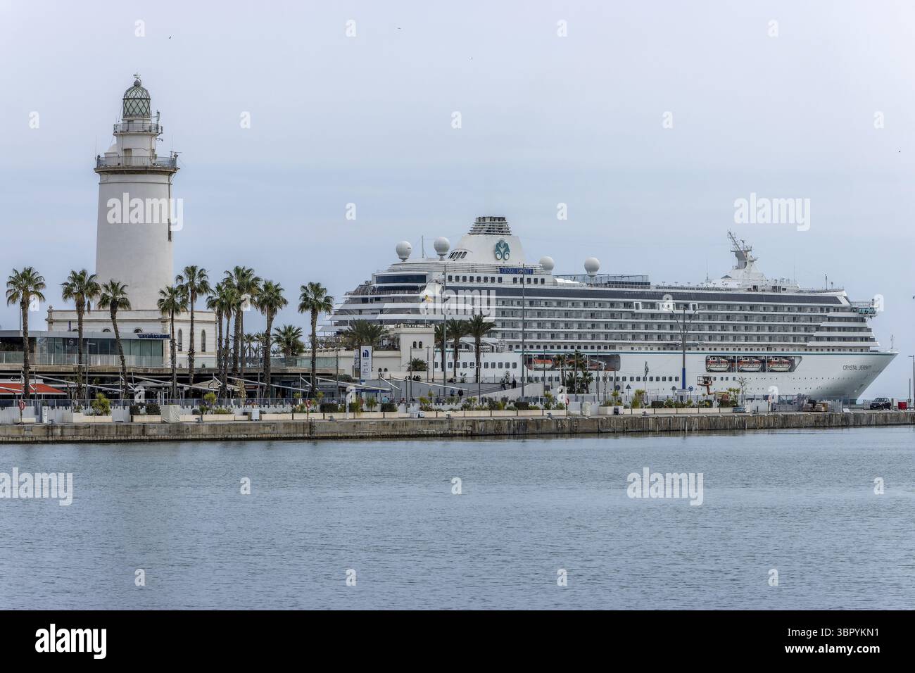 Phare la Farola de Malaga sur la place P.º de la Farola à l'entrée du port et en arrière-plan un grand bateau de croisière blanc (océan Banque D'Images Phare la Farola de Malaga sur la place P.º de la Farola à l'entrée du port et en arrière-plan un grand bateau de croisière blanc (océan Banque D'Images