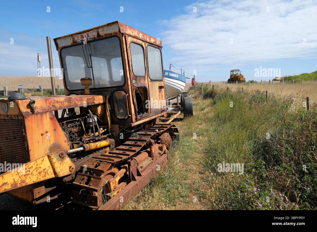 tracteur jaune sur la plage de galets de weybourne, nord du norfolk, angleterre Banque D'Images