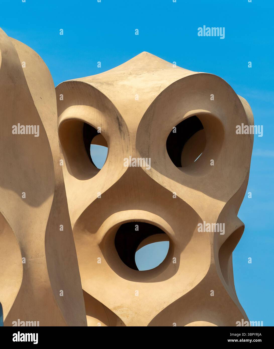 Gros plan d'une tour de ventilation sculpturale avec de grandes ouvertures ressemblant à des yeux sur le toit unique de Casa Milà (la Pedrera) à Barcelone, en Espagne. Banque D'Images
