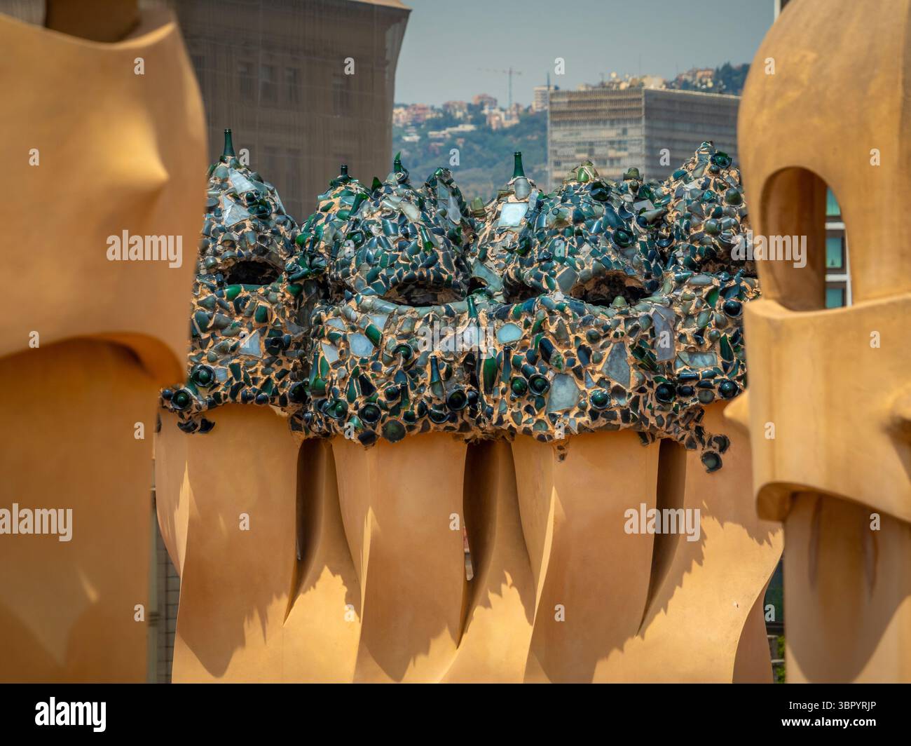 Cheminées fantastiques recouvertes de mosaïque de verre vert 'trencadís', fabriquées à partir de bouteilles de cava recyclées, sur le toit de Casa Milà, Barcelone, Espagne. Banque D'Images