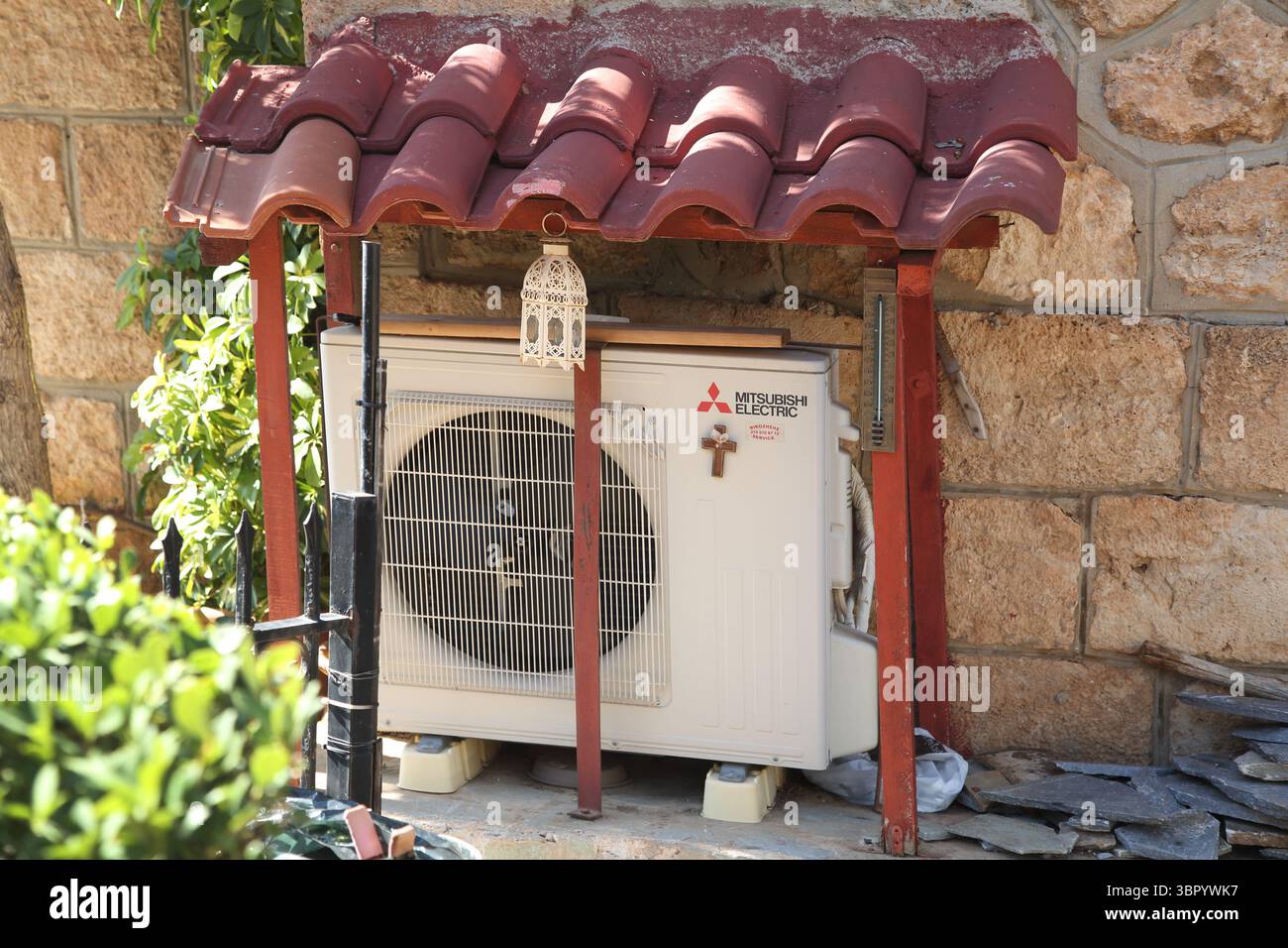 Unité de climatisation Mitsubishi Electric avec Croix sous un abri à l'extérieur de l'église Agios Nikolas Vari-Voula- Vouliagmeni Attica Grèce Banque D'Images