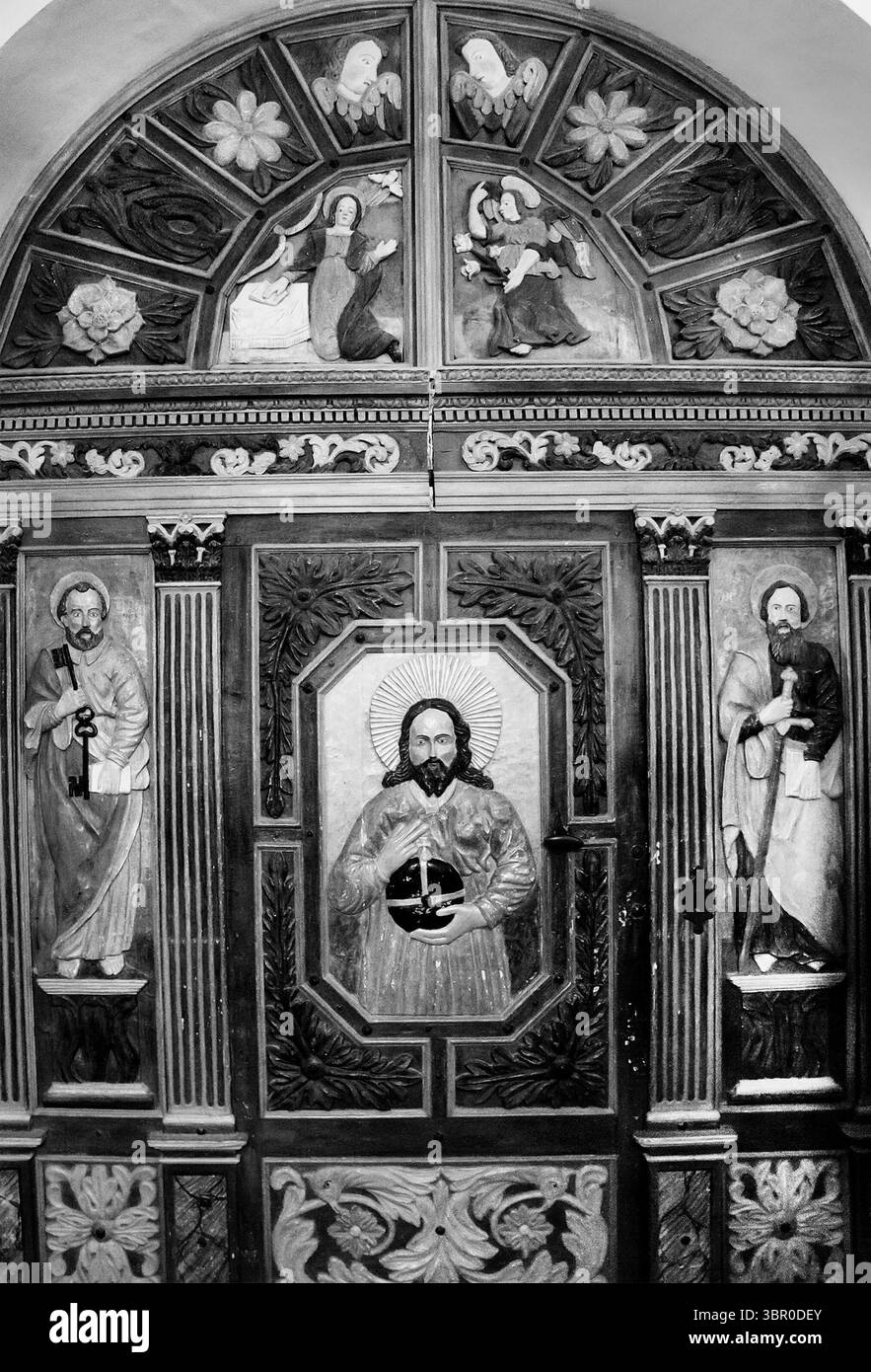 AVRIEUX, FRANCE - 11 AOÛT 2016 : porte sculptée représentant le Christ tenant un crucifère Globus ; scène de l'Annonciation ; apôtres. Banque D'Images