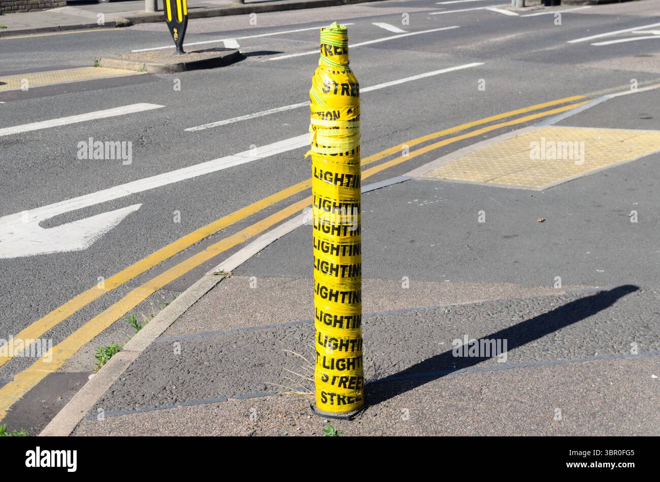 Un lampadaire complètement cassé en deux en étant heurté par une voiture avec du ruban jaune enroulé autour du Royaume-Uni Banque D'Images