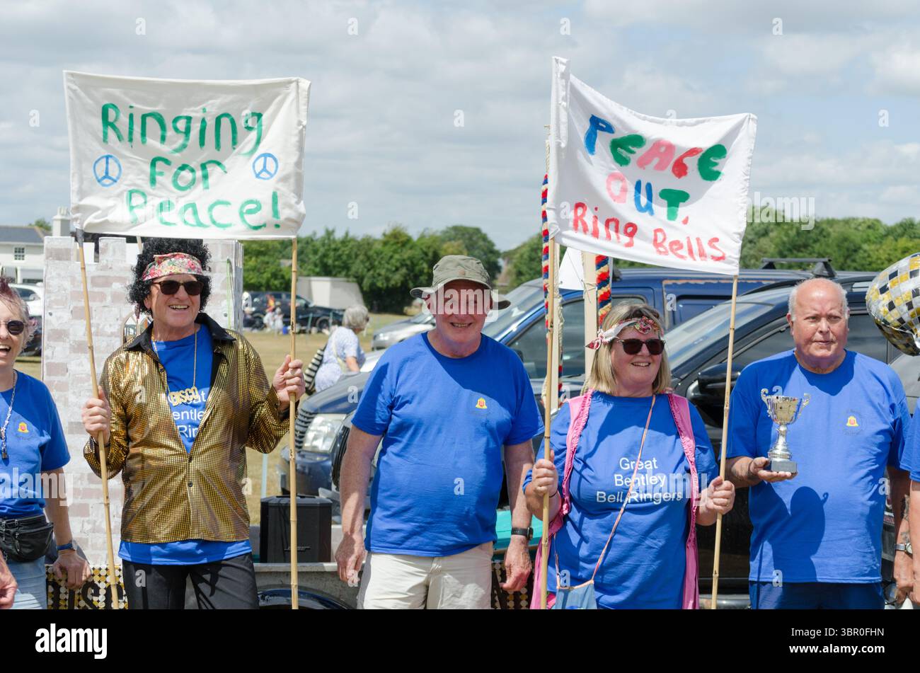 Un groupe de personnes déguisées en hippie tenant une bannière disant que la paix sonnera pour Peace Essex UK Banque D'Images