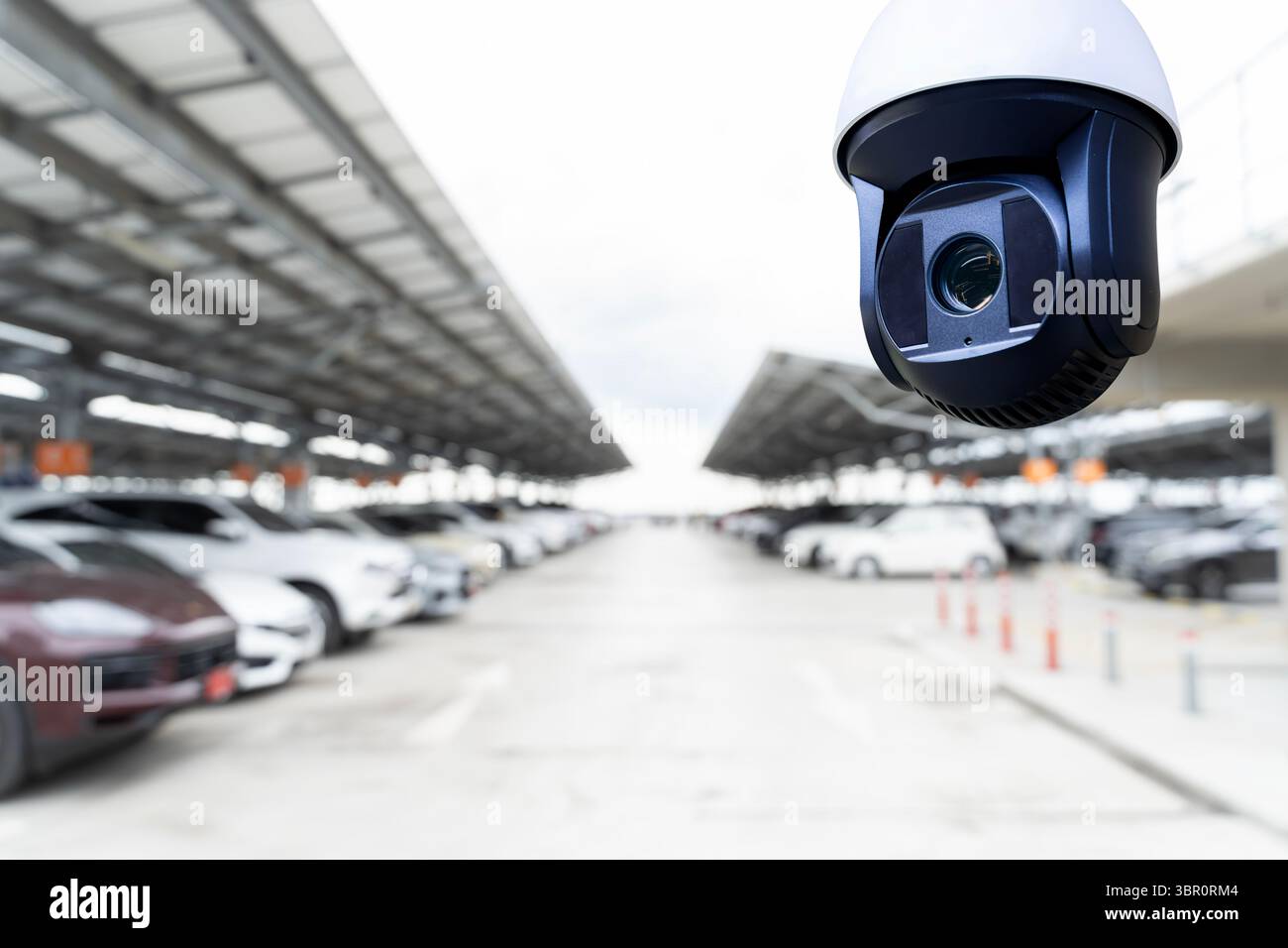 Gros plan du parking de surveillance de caméra de sécurité avec toit de panneau solaire et de nombreuses voitures garées. Concept de technologie, de sécurité, de surveillance, Banque D'Images