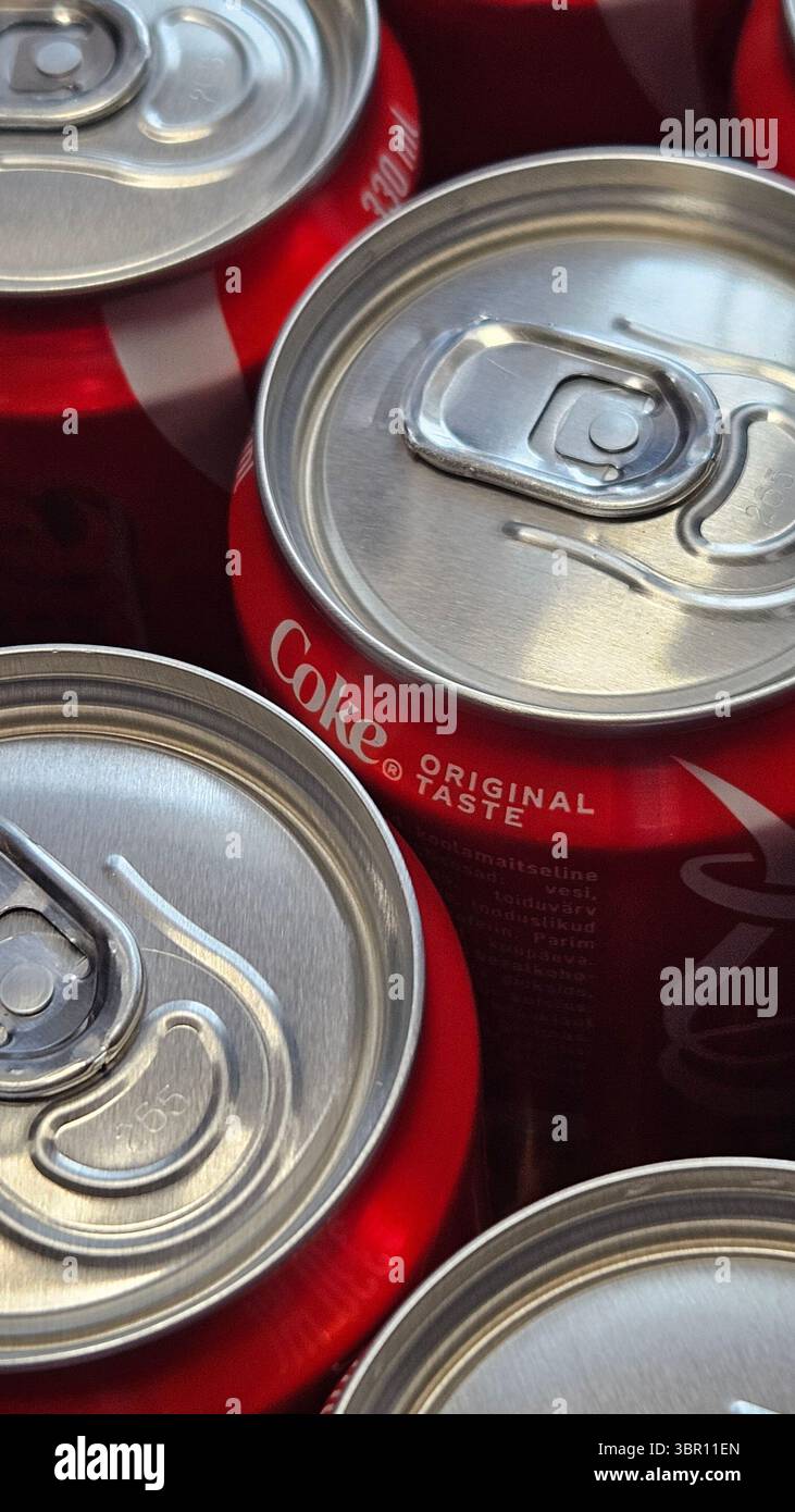 Gros plan des canettes de soda empilées – vue de dessus des conteneurs de boisson en aluminium Coca-Cola.Riga.Latvia.10.07.2025 - Image de stock capturée avec un smartphone