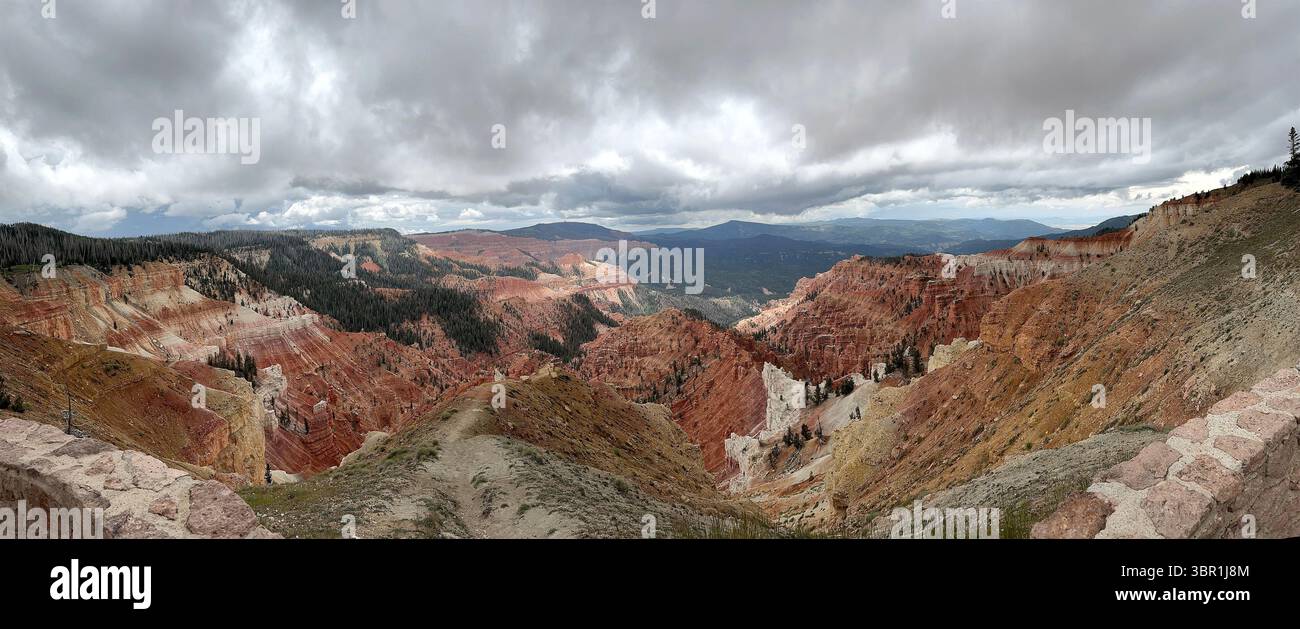 Vue panoramique sur un canyon rocheux Cedar Breaks National Monument de l'Utah sous un ciel nuageux avec des formations rocheuses rouges et oranges vibrantes Banque D'Images