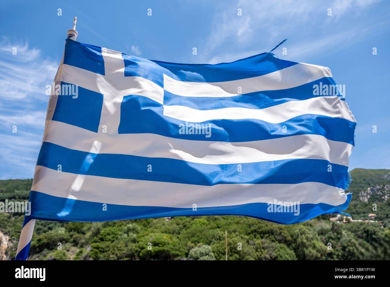 Symbole de signe Grèce. Drapeau national grec sur mât de drapeau ondulant dans le vent, ciel bleu avec des nuages Banque D'Images