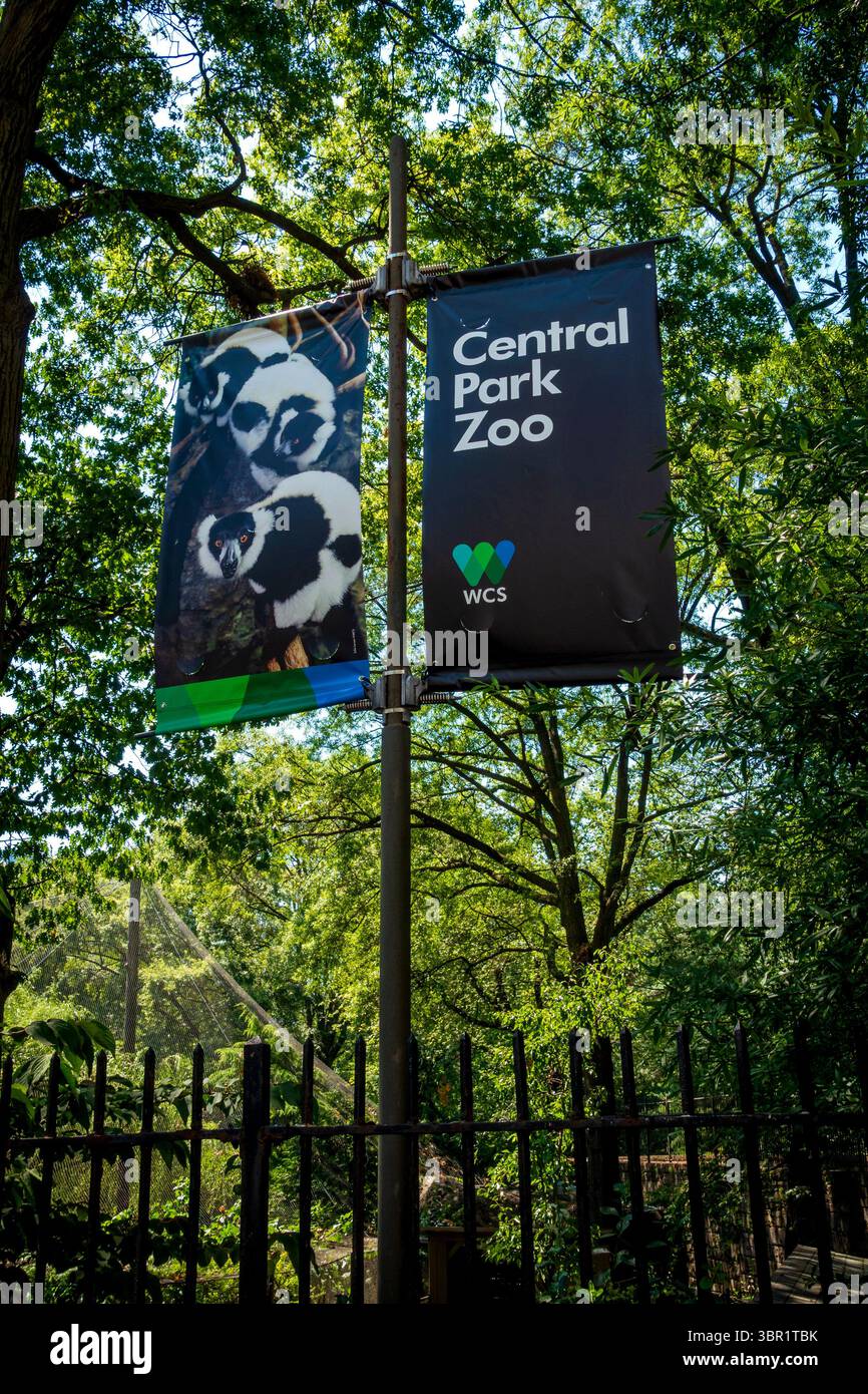 New York, NY - États-Unis - 6 juillet 2025 deux bannières sont accrochées à un poteau, l'une indiquant « Central Park Zoo » avec le logo de la WCS (Wildlife conservation Society), highlig Banque D'Images