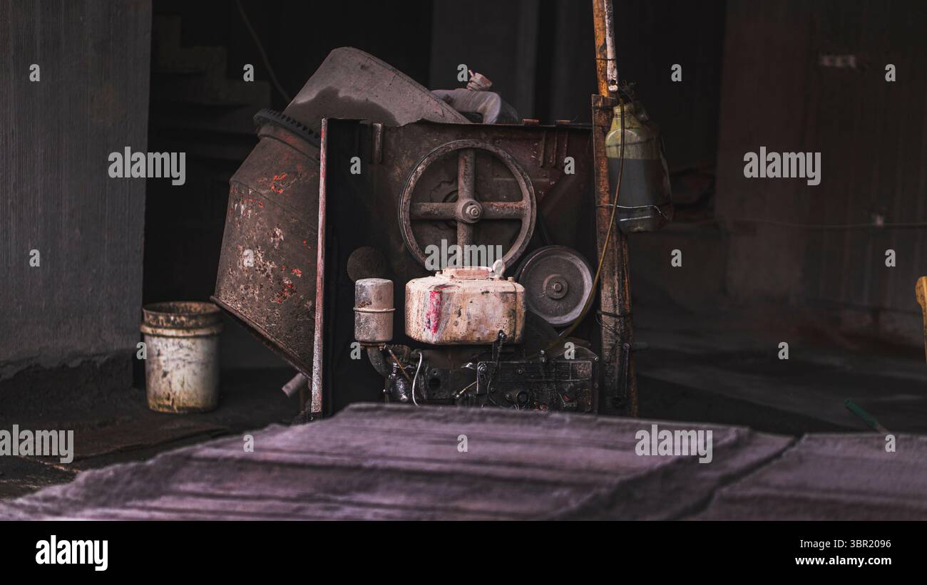 Vieux moteur diesel sur un chantier de construction, montrant la ténacité et l'usure de l'équipement lourd. Banque D'Images