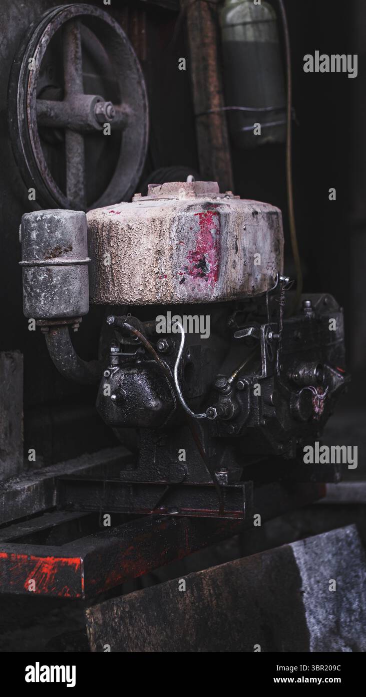 Vieux moteur diesel sur un chantier de construction, montrant la ténacité et l'usure de l'équipement lourd. Banque D'Images