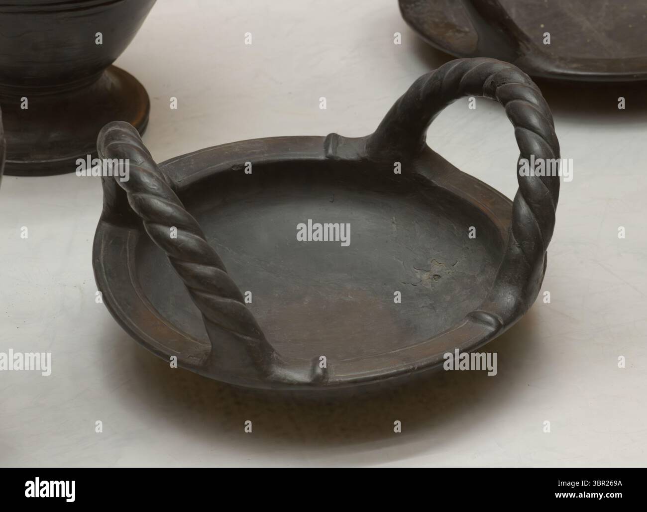 Poterie étrusque Bucchero du vie siècle av. J.-C. avec poignées torsadées, typique de l'artisanat italique antique. Exposé à Orvieto, Italie. Banque D'Images