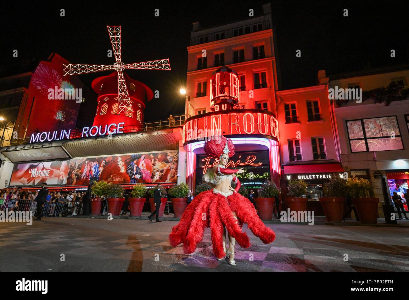 Paris, France. 10 juillet 2025. Une danseuse se produit devant le cabaret du Moulin Rouge alors que ses ailes tournent à Paris le 10 juillet 2025. Photo de Firas Abdullah/ABACAPRESS.COM crédit : Abaca Press/Alamy Live News Banque D'Images
