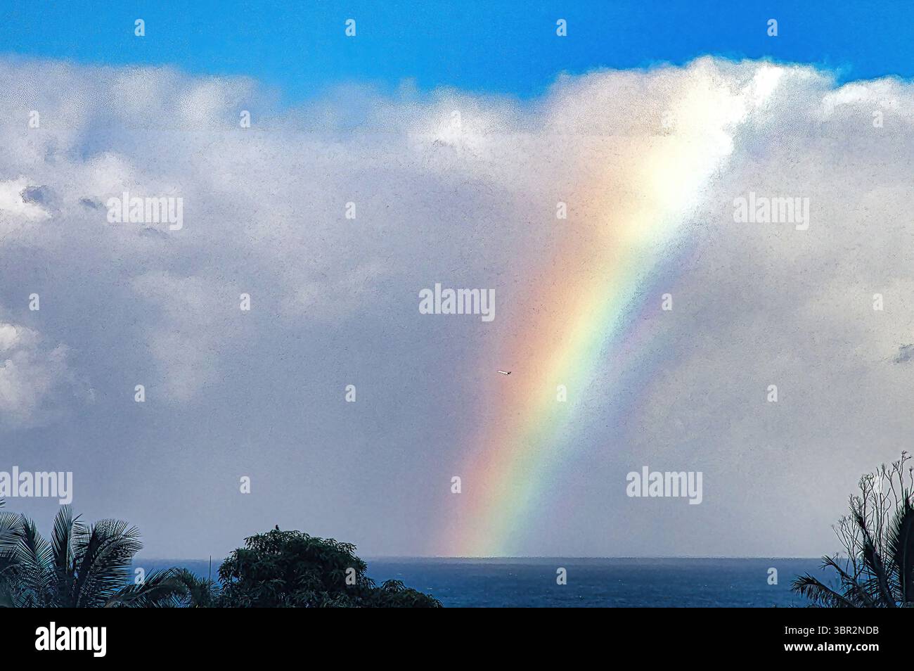 Arc-en-ciel descendant des nuages dans l'océan. Banque D'Images