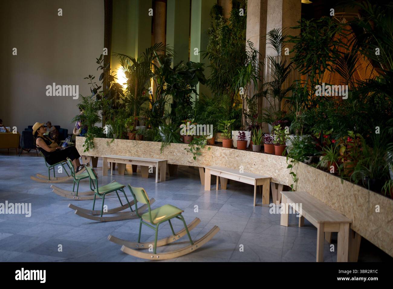Madrid, Espagne. 10 juillet 2025. Une femme est assise sur une balançoire, lors de la journée d’ouverture de l’abri climatique été 2025 installé au Círculo de Bellas Artes dans le centre de Madrid. Le Círculo de Bellas Artes utilise la salle de bal comme abri climatique, avec plus de 300 plantes et hamacs géants pour fournir une protection gratuite aux citoyens contre les températures urbaines élevées pendant l'été. Crédit : SOPA images Limited/Alamy Live News Banque D'Images