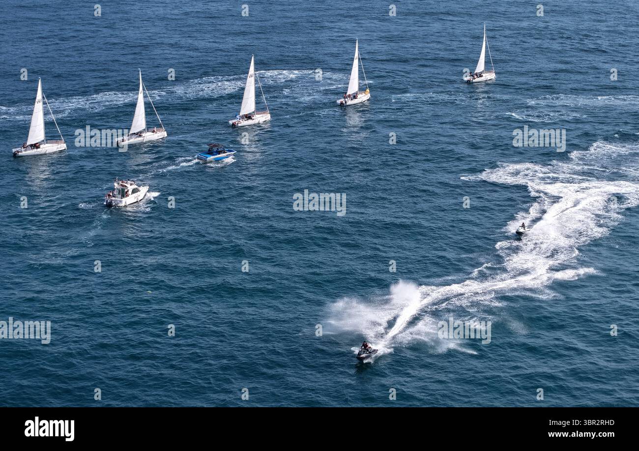 Pékin, Chine. 10 juillet 2025. Une photo de drone aérien prise le 10 juillet 2025 montre des yachts et des voiliers participant à un événement de croisière en mer dans la région de la baie de Laolong à Qingdao, dans la province du Shandong de l'est de la Chine. Un événement de croisière en mer a eu lieu jeudi dans la ville côtière de Qingdao pour célébrer le 20e anniversaire de la création de la Journée maritime de la Chine et le 620e anniversaire des voyages maritimes de l'explorateur chinois Zheng He. Crédit : Li Ziheng/Xinhua/Alamy Live News Banque D'Images