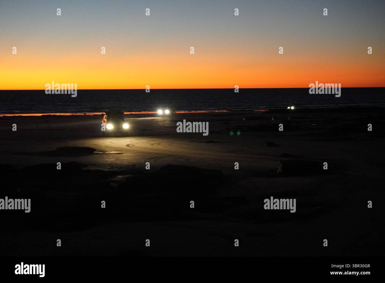 Voitures quittant Cable Beach de Broome après le coucher du soleil Banque D'Images