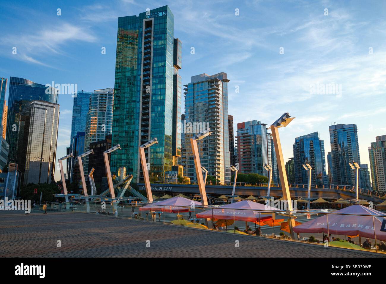 Jack Poole Plaza, près du Chaudron olympique avec les restaurants Tap & Barrel & Cactus Club à proximité et les condos Coal Harbour au-delà, Vancouver, C.-B. Banque D'Images