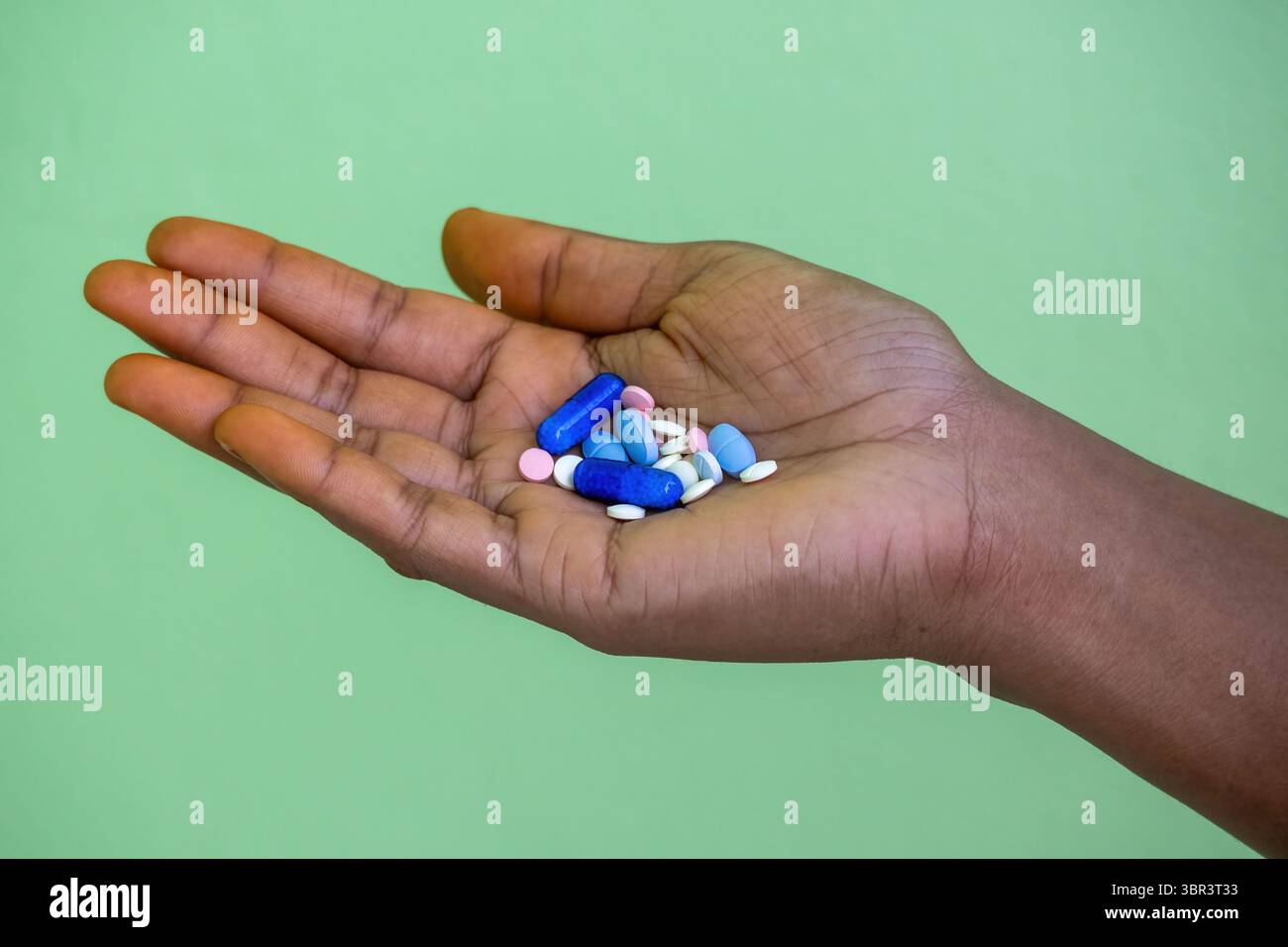 Gros plan de la main d'une femme tenant diverses pilules et capsules. Concepts de dépression, surdose, suicide, toxicomanie, abus de stupéfiants, et mental h Banque D'Images