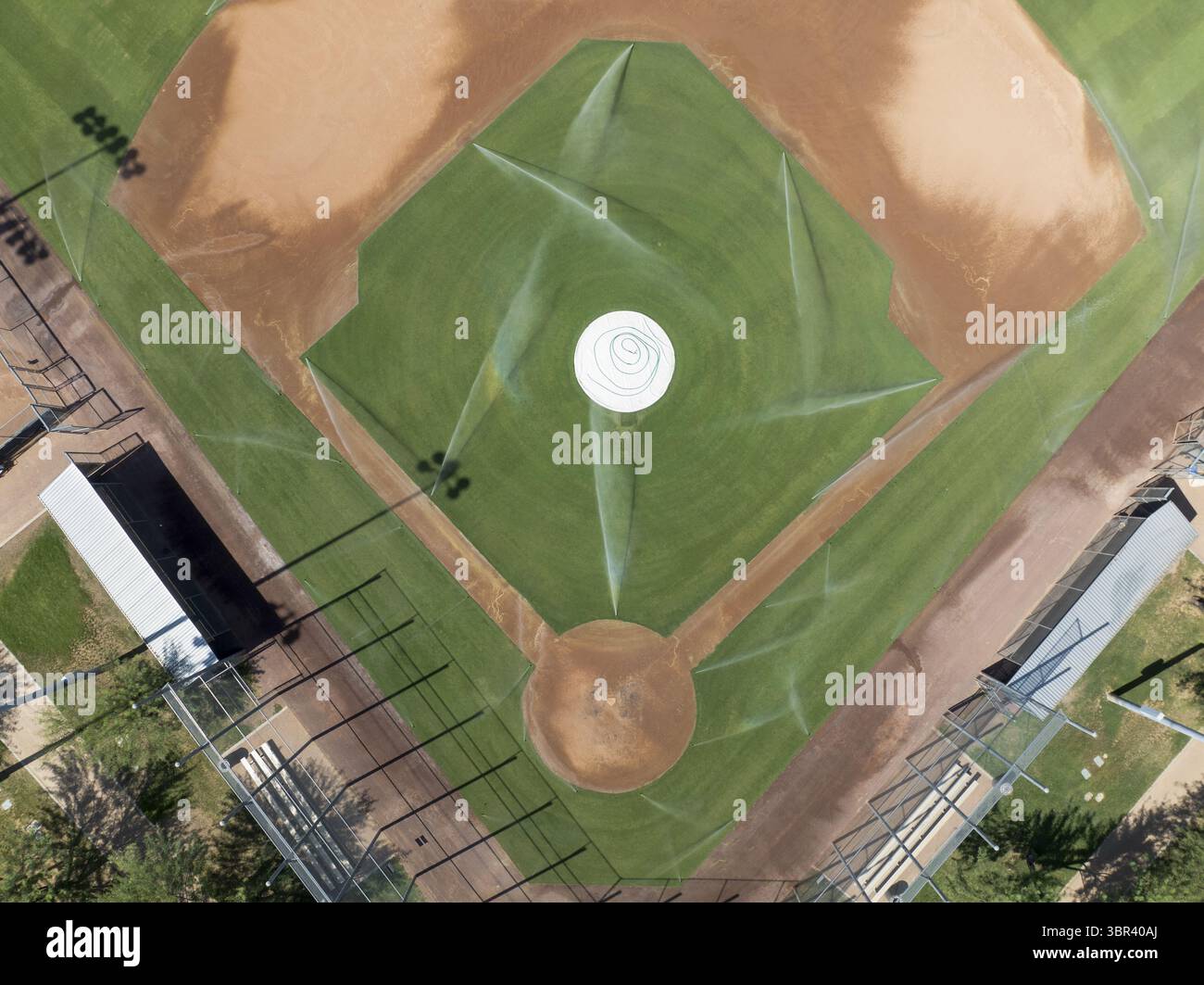 Vue aérienne d'un terrain de baseball avec des gicleurs arrosant l'herbe verte luxuriante et la terre brune contrastée, Scottsdale, Arizona, États-Unis. Banque D'Images