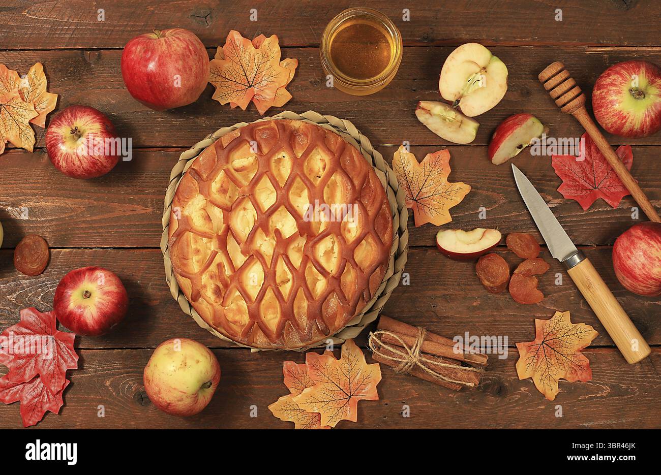 Fond d'automne de cuisine avec tarte aux pommes, miel, pommes, épices et fleurs et feuilles de saison, concept chaleureux confortable, bonjour automne, style hygge, moderne Banque D'Images