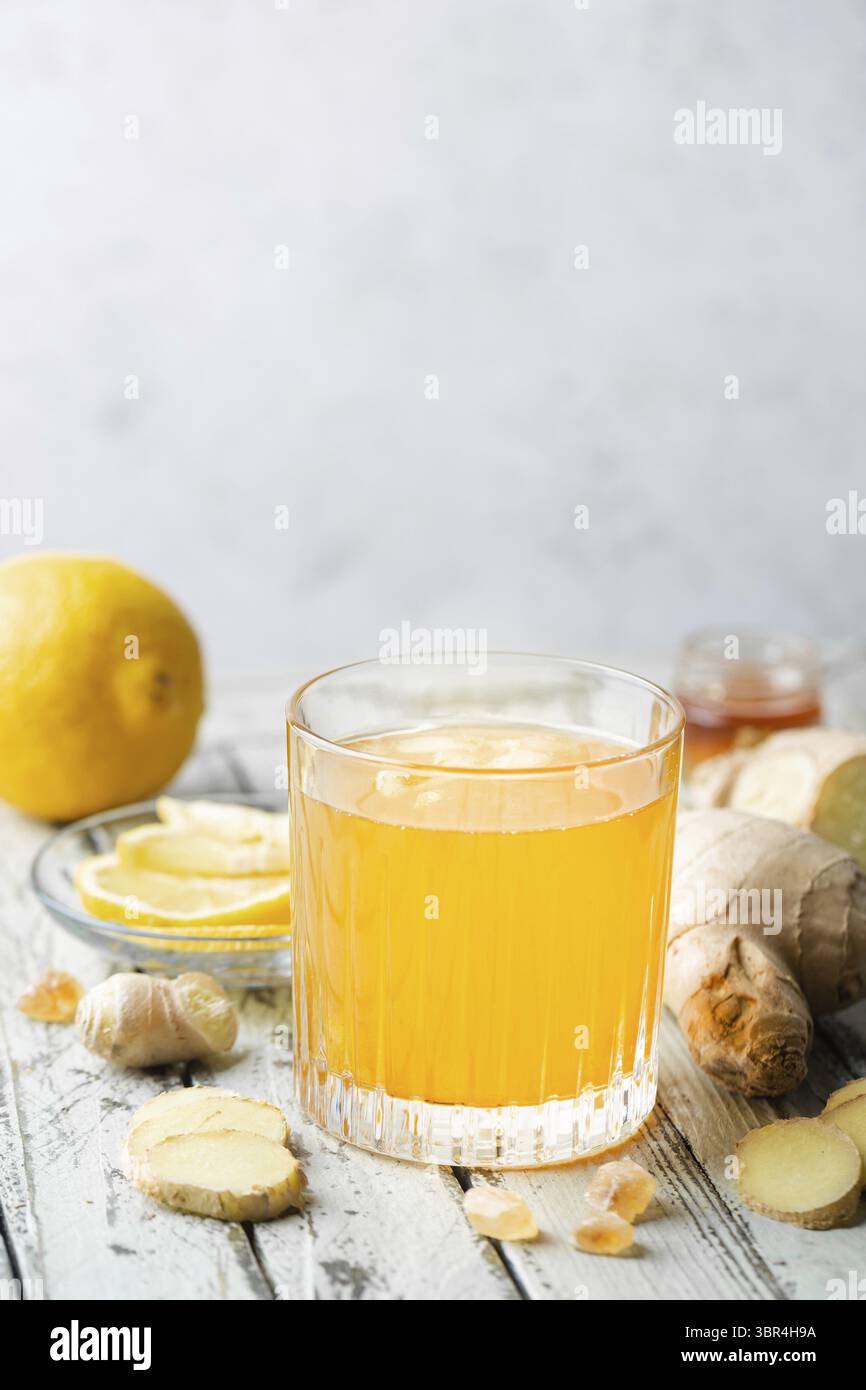 Boisson jaune au gingembre, au citron et à la glace dans un verre, limonade au gingembre maison rafraîchissante ou ALE sur fond blanc Banque D'Images
