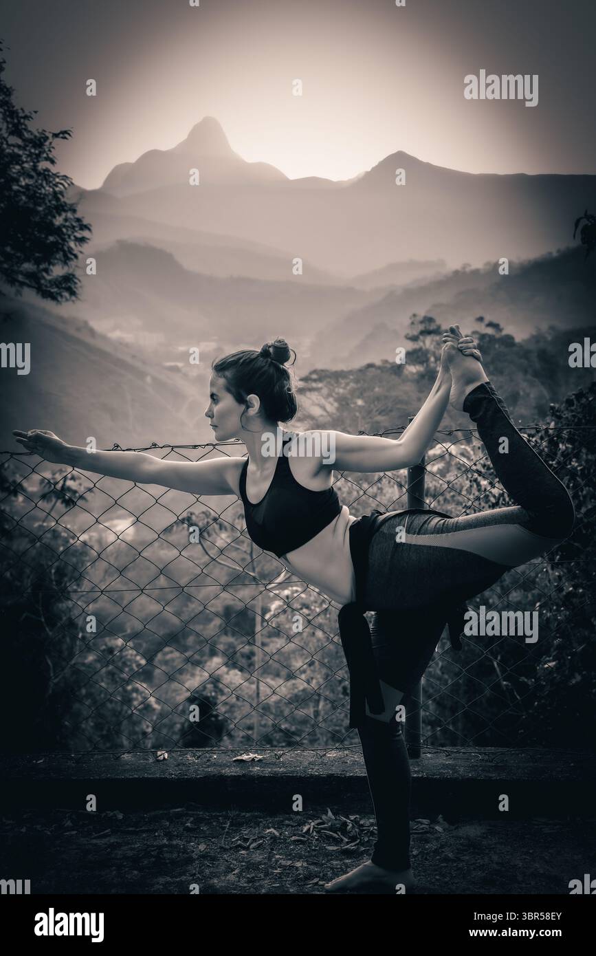 Photo en noir et blanc d'une femme pratiquant le yoga à Itaipava avec paysage de montagne Banque D'Images