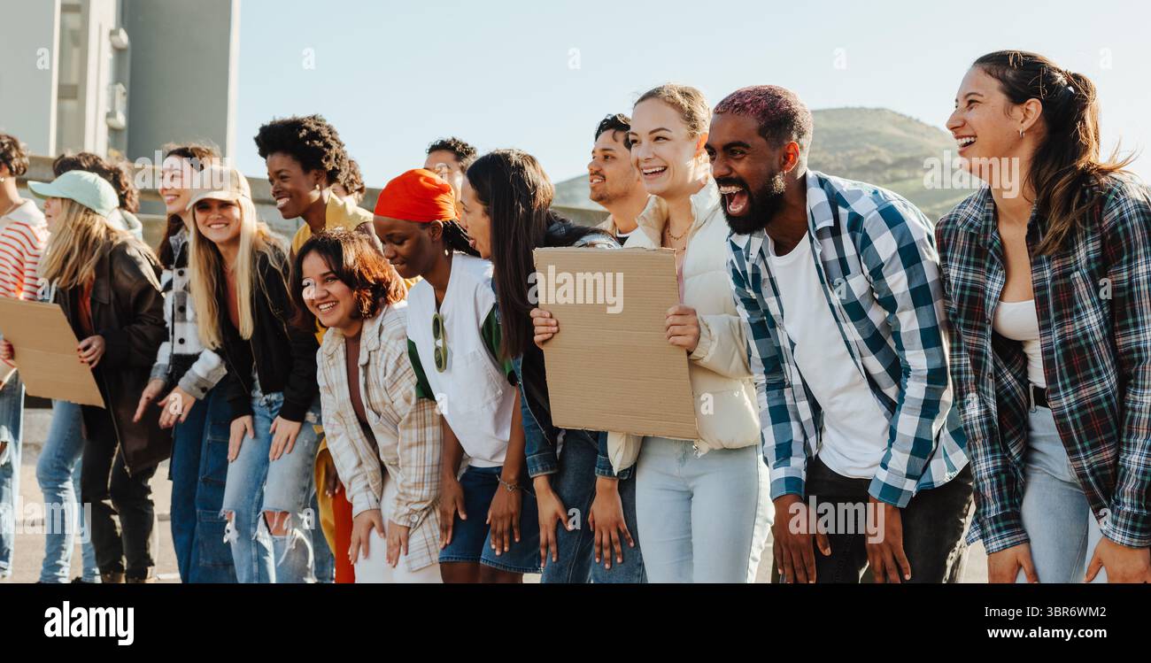 Un rassemblement joyeux de jeunes activistes divers en plein air, riant et partageant une énergie positive. Le groupe exprime camaraderie et joie, incarnant fri Banque D'Images