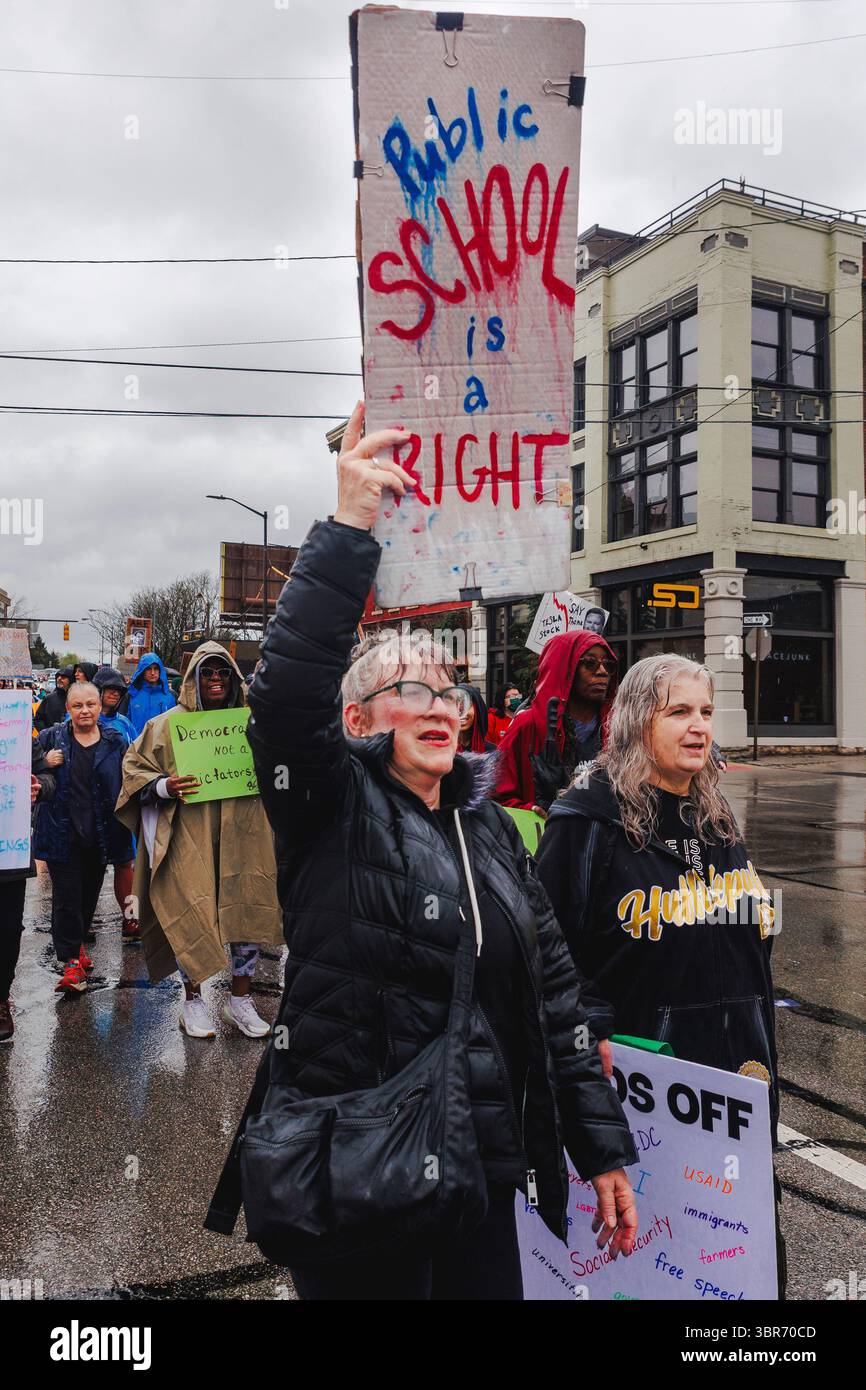 Deux femmes âgées défilent en protestation sous la pluie avec des pancartes Banque D'Images
