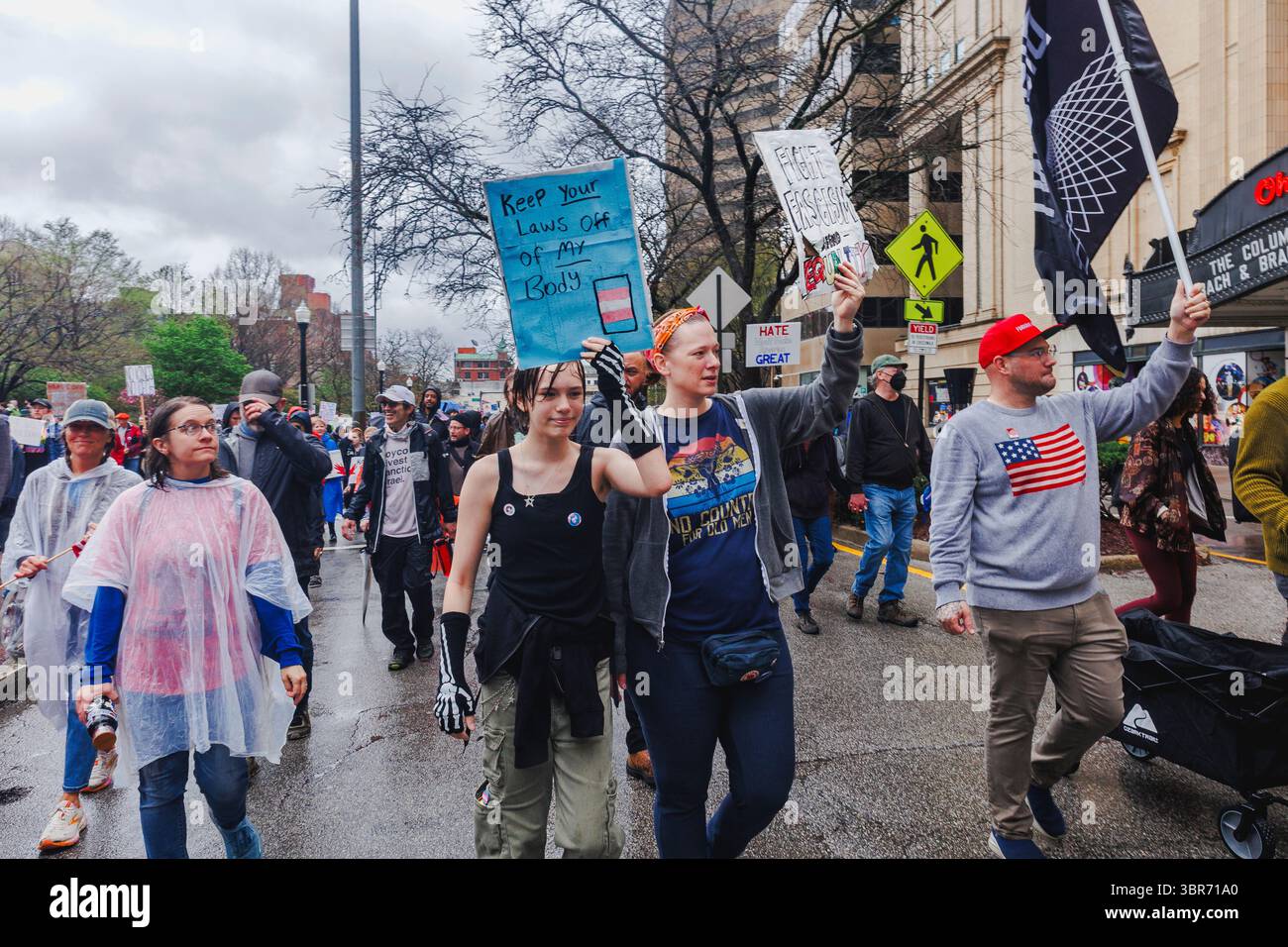 Une foule marche contre le fascisme sous la pluie tenant des pancartes Banque D'Images