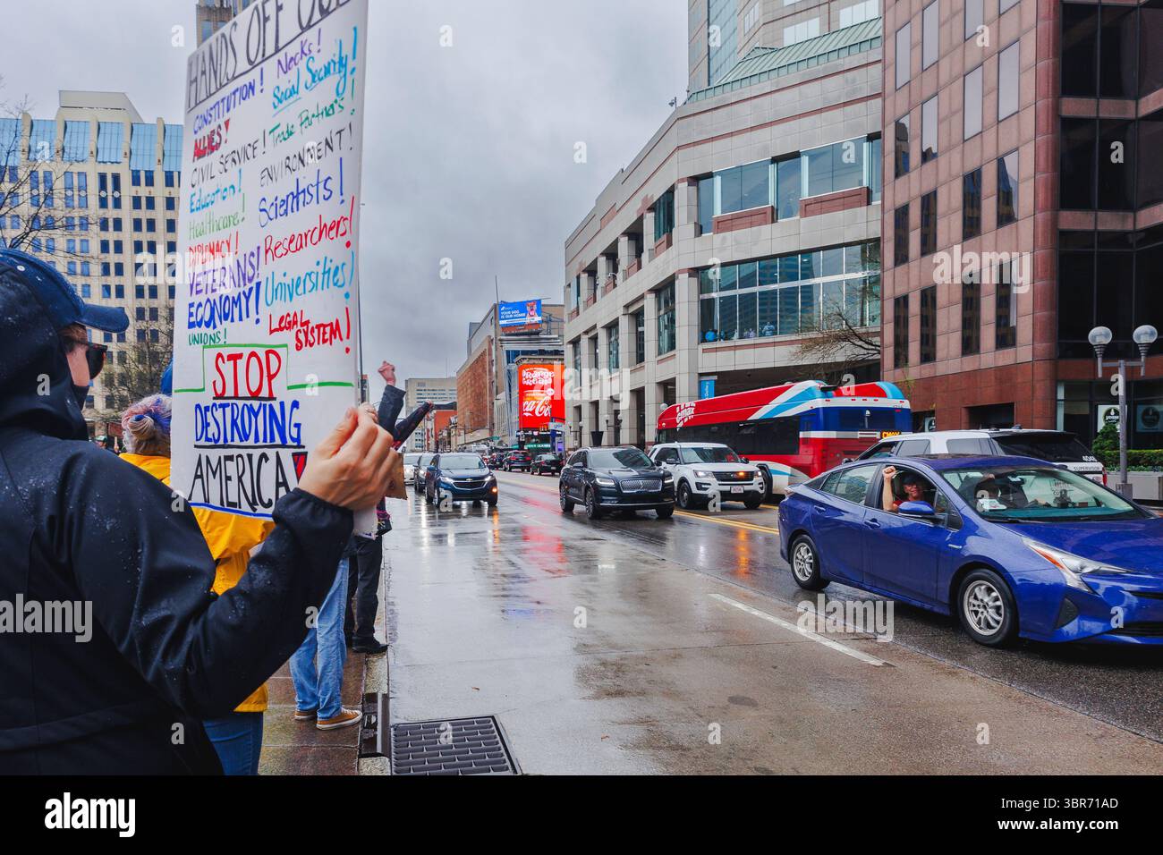 Les passagers de voitures encouragent les manifestants dans la rue qui tiennent des pancartes Banque D'Images
