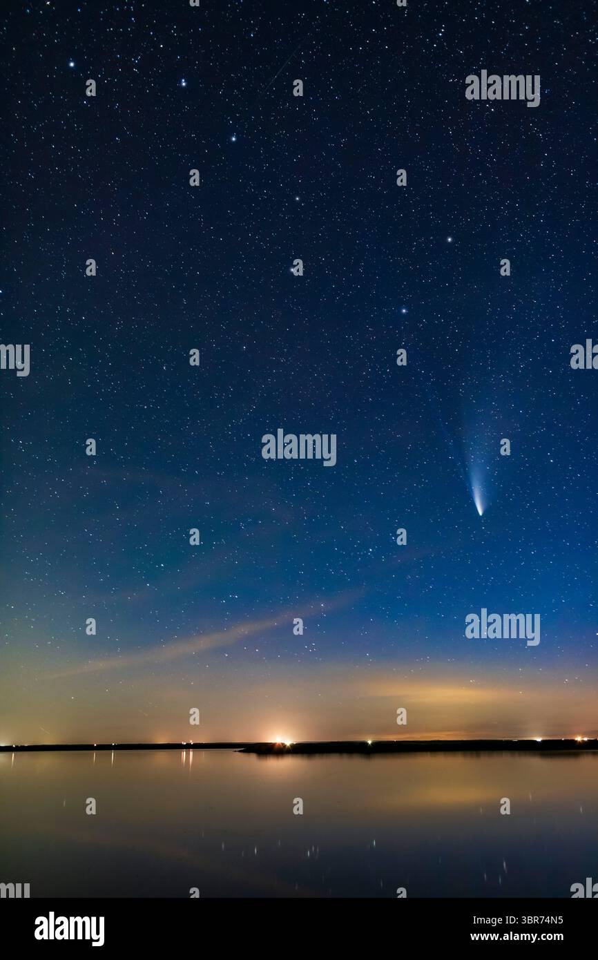 21 juillet 2020, Alberta, Canada : comète NEOWISE (C/2020 F3) au-dessus des eaux tranquilles cette nuit du lac Crawling dans le sud de l'Alberta. Le Big Dipper est au sommet. Même dans cette courte exposition, les deux queues — poussière et ion — sont visibles. C'était le 20 juillet 2020. La queue ionique bleue se prolonge dans le bol de la Big Dipper, sur une longueur de 20°. Très impressionnant ! ..le contenu principal de l'image est une exposition unique sans suivi de 20 secondes à f/2,2 et ISO 3200 avec l'objectif Canon 35mm et Canon 6D MkII. Les nuages lointains, l'horizon et l'eau dans la distance et dans l'immédate renoncent sans étoiles Banque D'Images