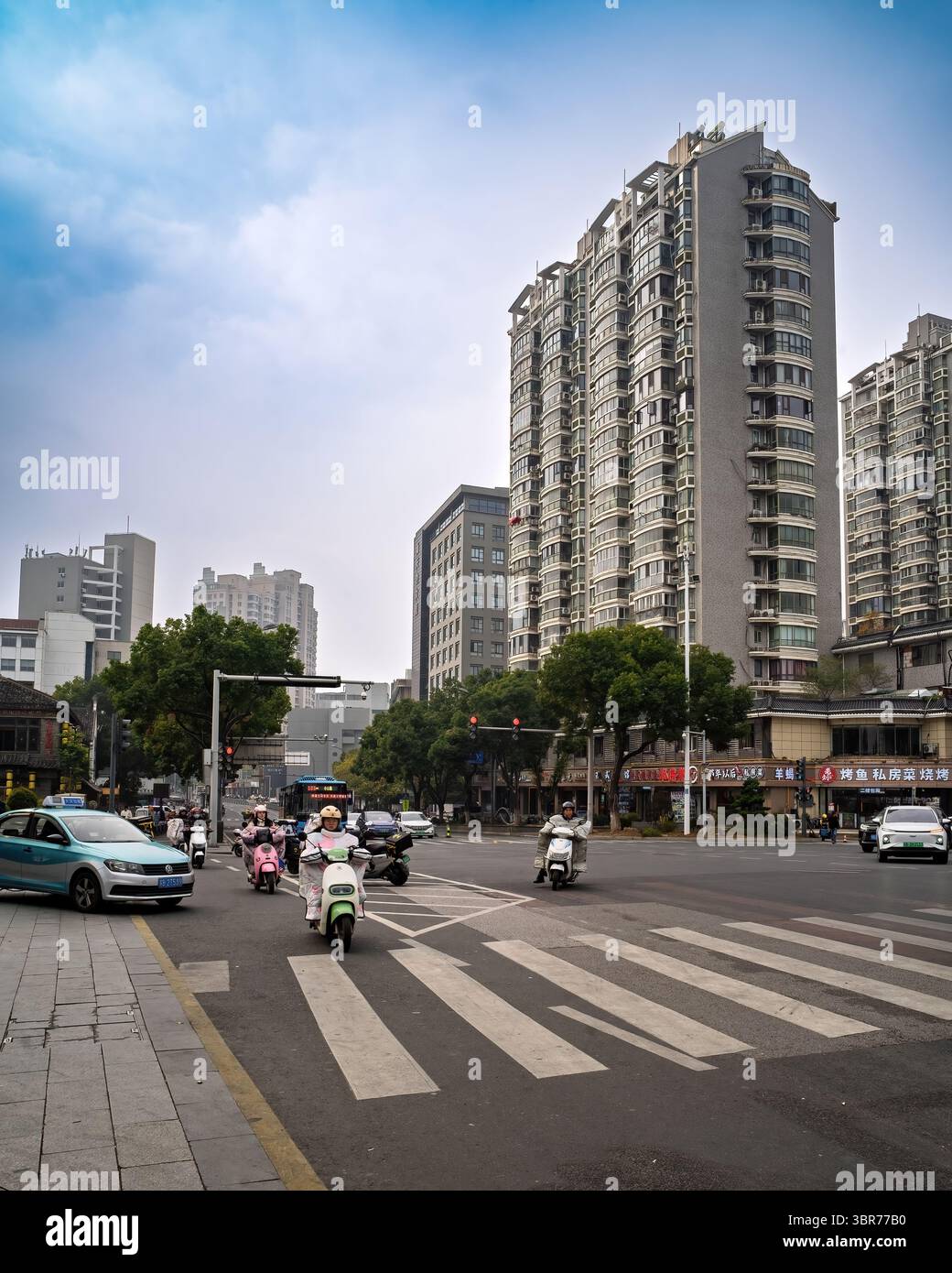 Route très fréquentée avec des motos et des voitures à l'intersection de la rue. Banque D'Images