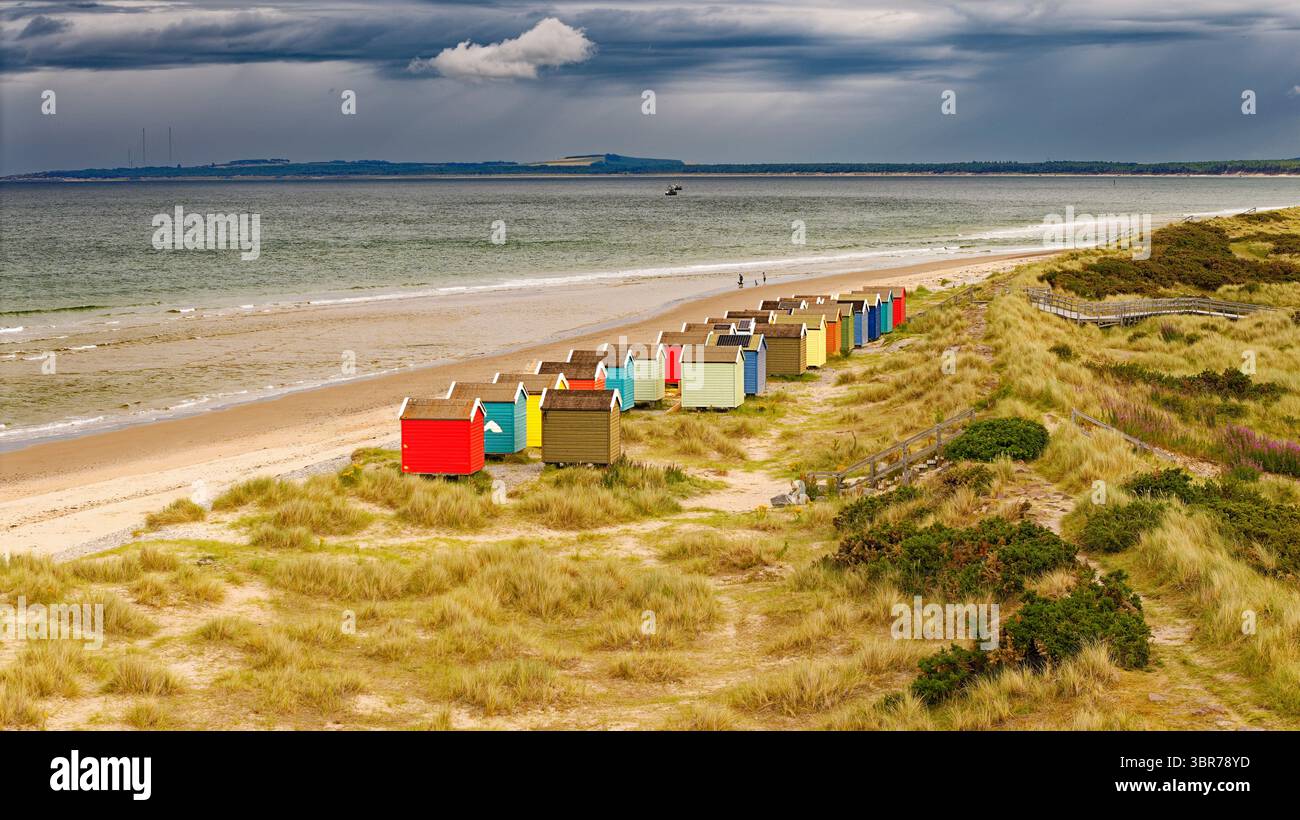 Findhorn Moray Coast Scotland cabanes de plage colorées sous un ciel tonnerre en été Banque D'Images