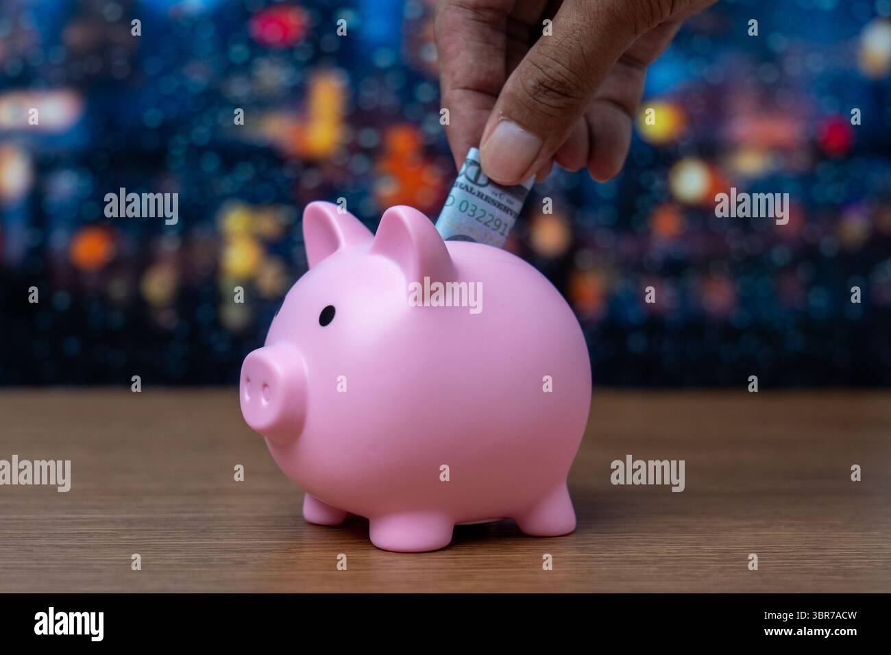 Une main insère un billet d'un dollar plié dans une tirelire. Finance, concept d'économie d'argent. Banque D'Images