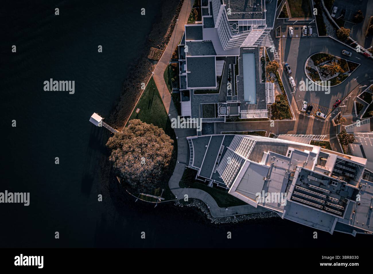Vue aérienne des eaux sombres contrastant avec l'architecture blanche angulaire et les espaces verts le long de l'estran de Mandurah, Mandurah, Australie occidentale, Australie. Banque D'Images