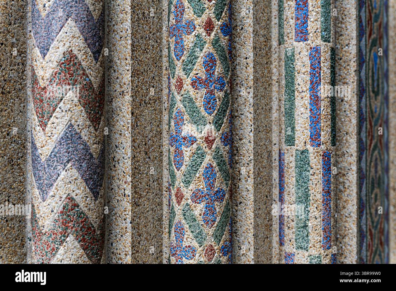 WASHINGTON DC — des motifs géométriques en mosaïque encadrent la porte voûtée à l'entrée principale du reptile Discovery Center du zoo national, créé en utilisant la technique innovante de mosaïque de béton de John Joseph Earley en 1931. Les dessins géométriques colorés ont été exécutés en utilisant le même 'Earley Process' employé pour la célèbre mosaïque de stégosaure du bâtiment, mélangeant le verre coloré broyé et l'agrégat de marbre directement dans le ciment Portland blanc. Ces panneaux de béton préfabriqués ont été fabriqués dans le studio Earley de Rosslyn, Virginie et ancrés au béton structurel avec des boucles de fil. Les répétitions géométriques c Banque D'Images