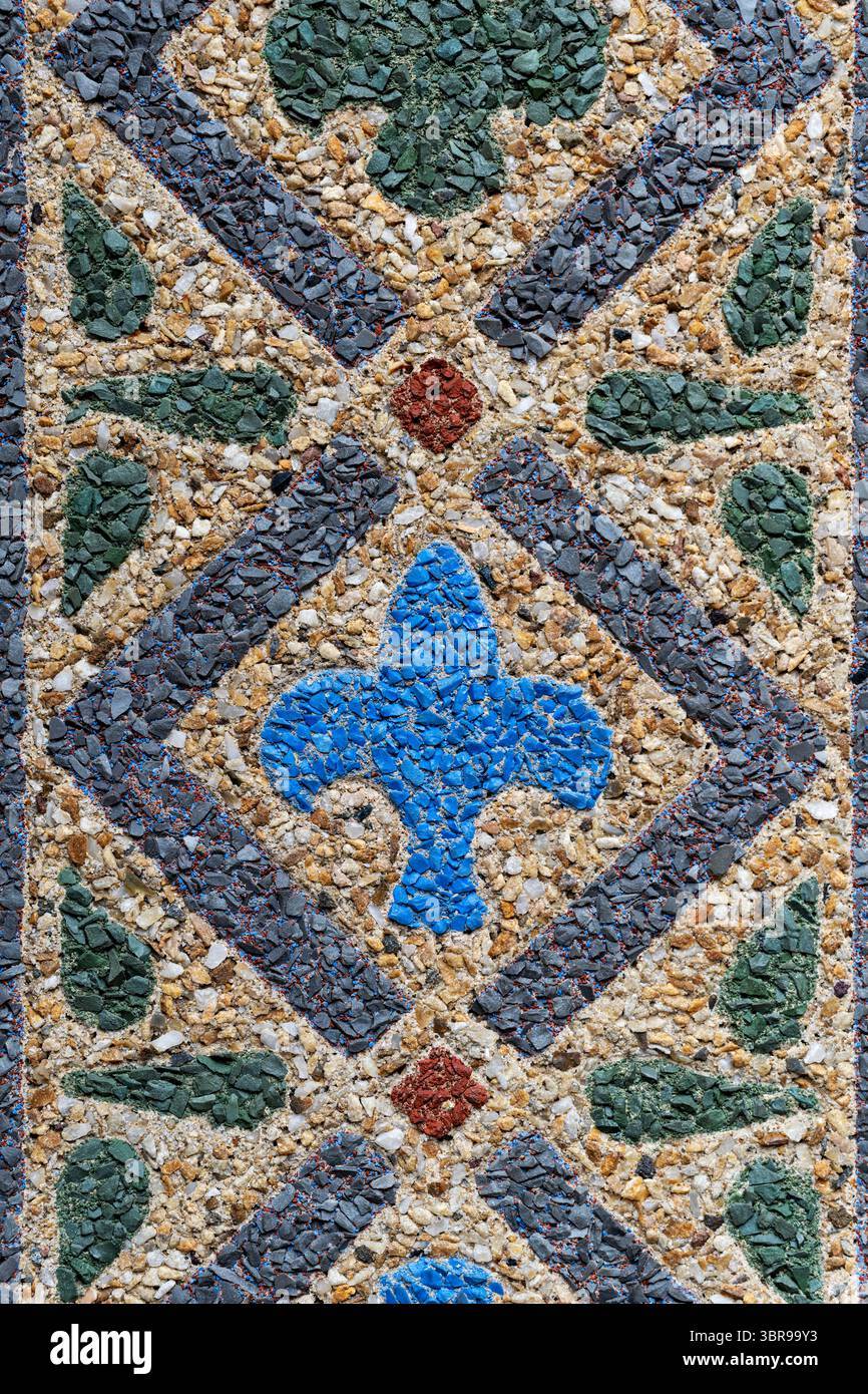 WASHINGTON DC — des motifs géométriques en mosaïque encadrent la porte voûtée à l'entrée principale du reptile Discovery Center du zoo national, créé en utilisant la technique innovante de mosaïque de béton de John Joseph Earley en 1931. Les dessins géométriques colorés ont été exécutés en utilisant le même 'Earley Process' employé pour la célèbre mosaïque de stégosaure du bâtiment, mélangeant le verre coloré broyé et l'agrégat de marbre directement dans le ciment Portland blanc. Ces panneaux de béton préfabriqués ont été fabriqués dans le studio Earley de Rosslyn, Virginie et ancrés au béton structurel avec des boucles de fil. Les répétitions géométriques c Banque D'Images