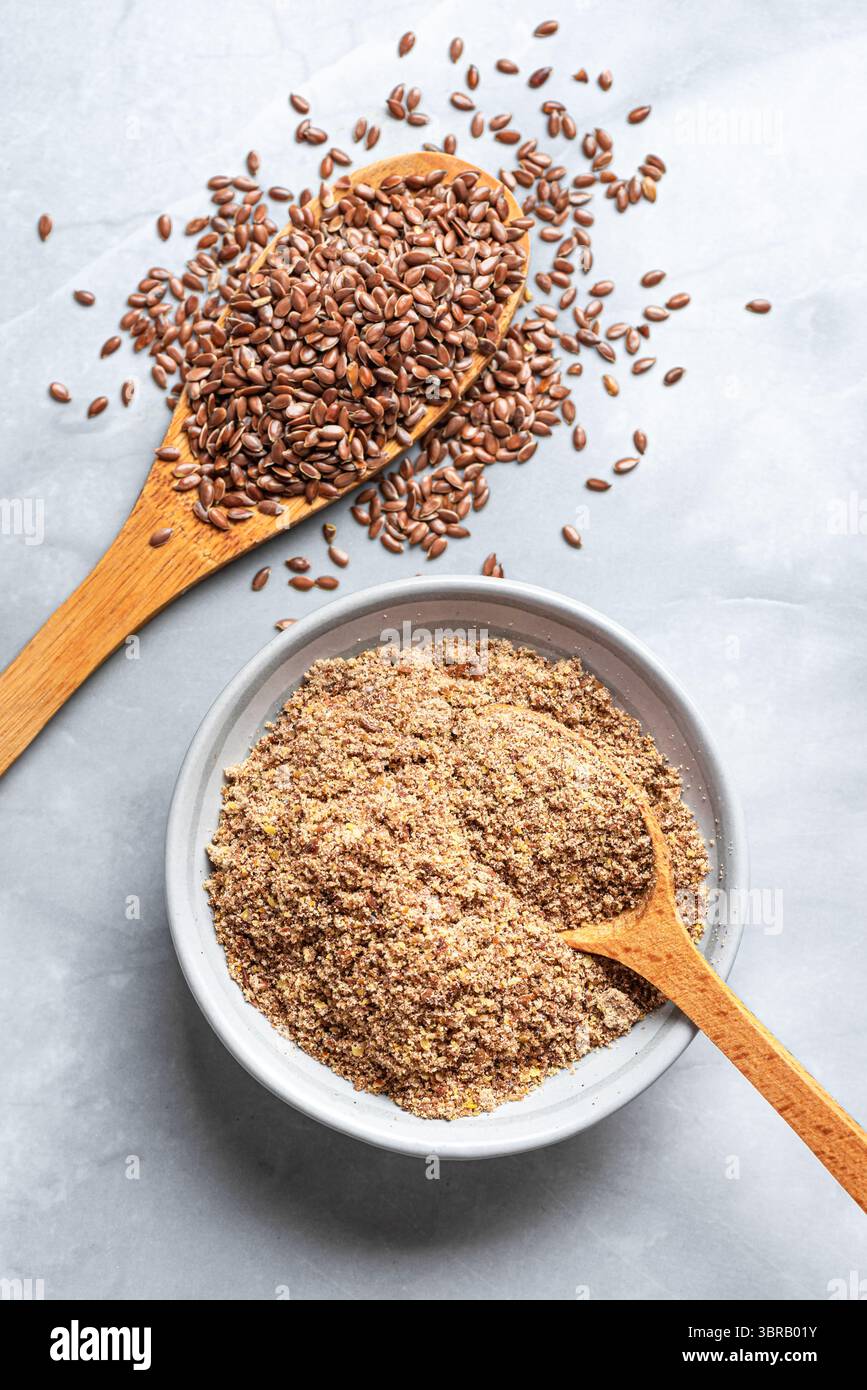 Graines de lin entières et moulues de graines de lin sur fond de marbre, vue de dessus. Alimentation saine. Produit biologique. Banque D'Images