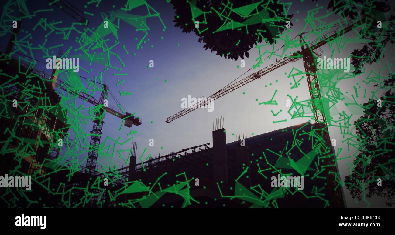 doté de trois grues à tour autour d'un cadre en béton sur le chantier de construction au crépuscule, avec recouvrement vert Banque D'Images