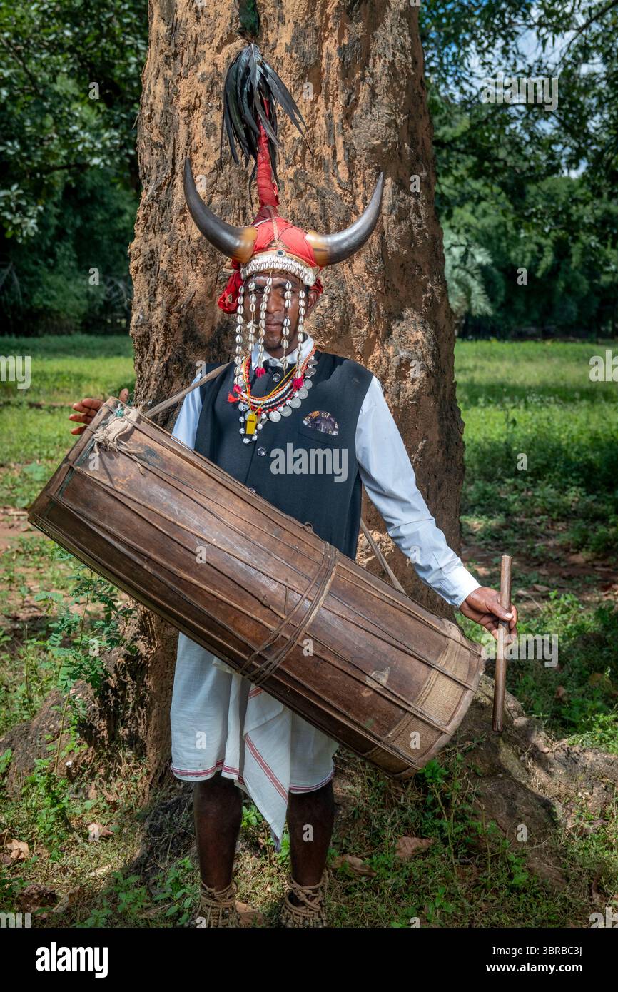 Portant une coiffe en corne de bison et jouant du tambour du tronc d'arbre creusé, un membre de la tribu Maria Gond dans le Chhattisgarh, Inde, Asie Banque D'Images