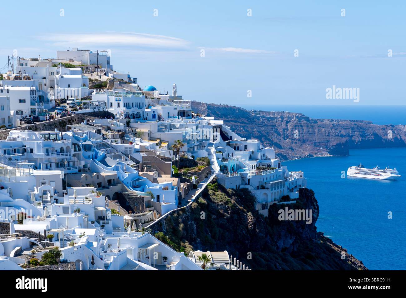 Vue de la ville d'Oia avec bateau de croisière en arrière-plan sur l'île de Santorin, Grèce. Banque D'Images
