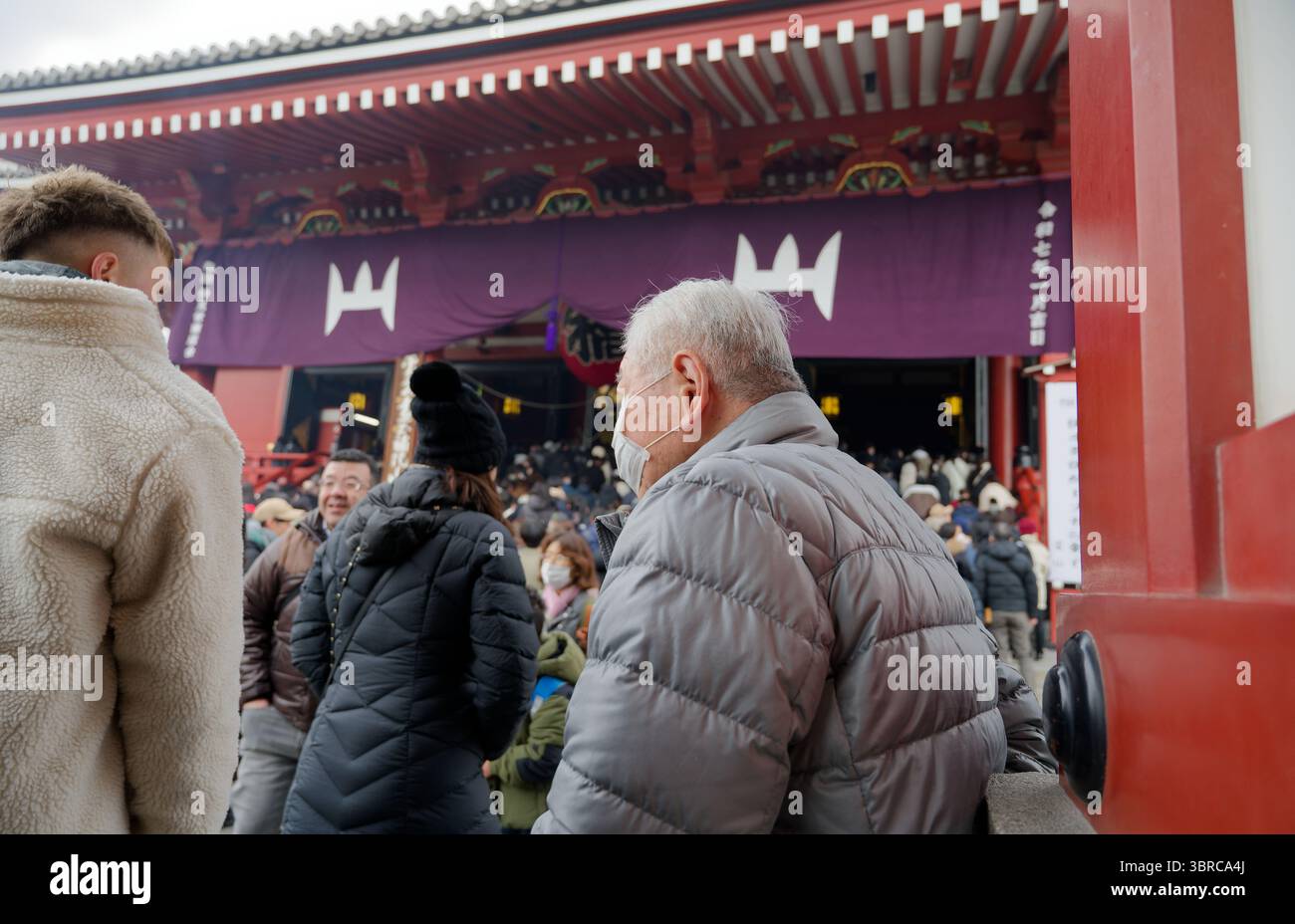 L'aîné local prend une pause près de l'entrée animée du temple Senso Ji Banque D'Images