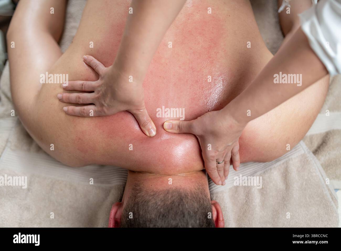 L'effleurage, ou mouvements de glisse doux, suit l'exfoliation pour détendre les muscles, répartir uniformément le gommage et améliorer la texture de la peau. Cela favorise la relaxation et une peau plus lisse et plus saine. Banque D'Images