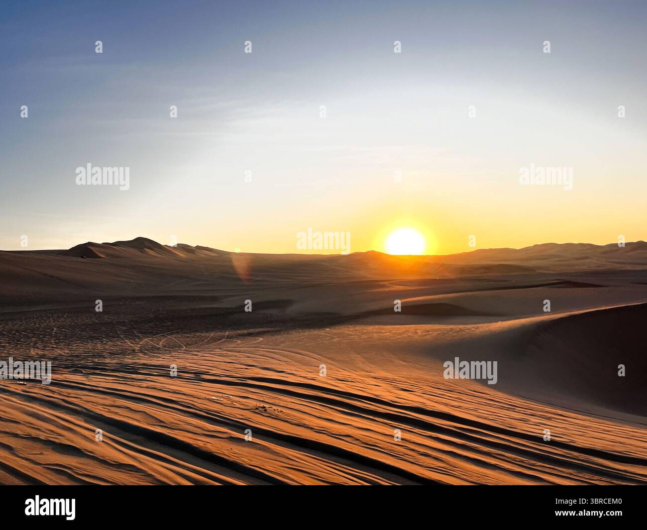 Soleil descendant derrière les dunes de sable dans le désert paysage aride Huacachina, ICA, Pérou. Destination touristique pour sports extrêmes, aventure en buggy. Banque D'Images