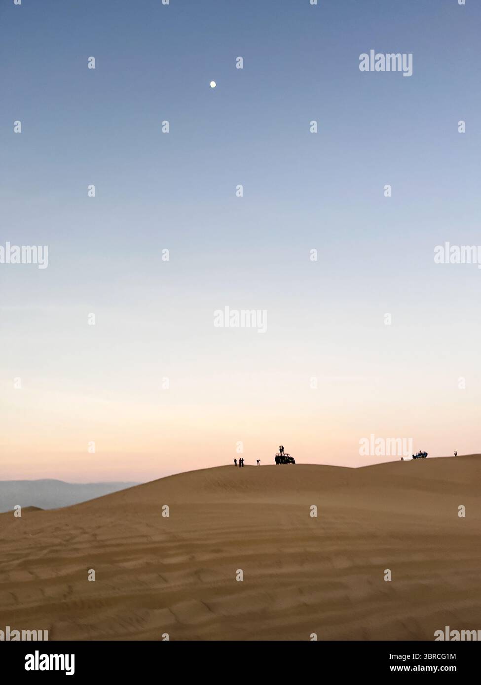 Belle vue sur les dunes de sable dans le désert à l'heure du coucher du soleil lever avec buggy car et touriste en arrière-plan à Huacachina, ICA, Pérou. Destination touristique Banque D'Images