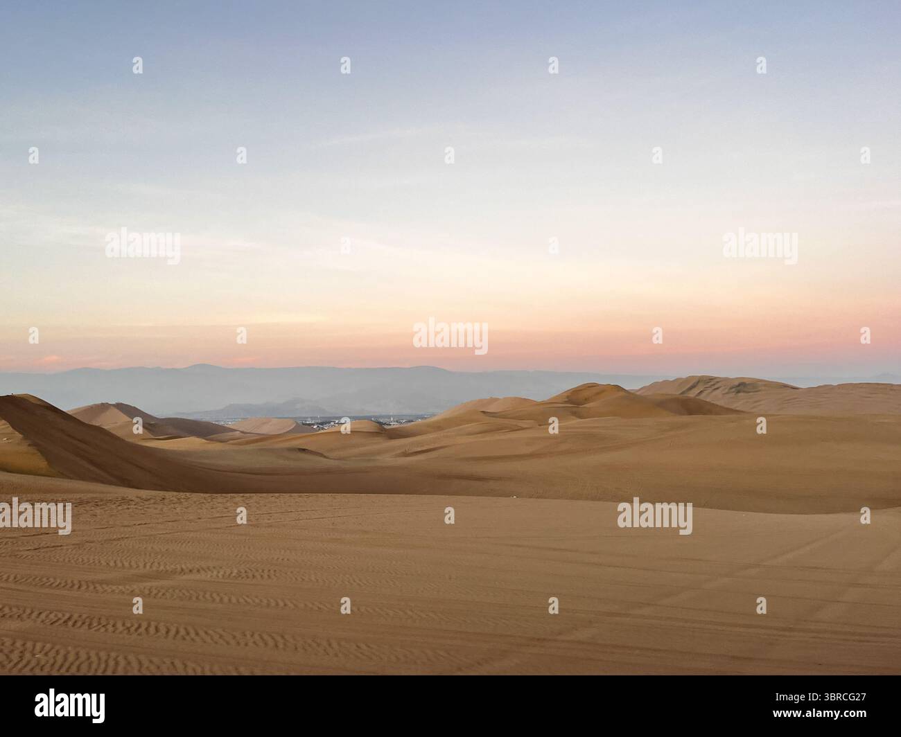 Vue infinie sur les dunes de sable dans le paysage désertique à l'heure du coucher du soleil au lever du soleil. Paysage aride Huacachina, ICA, Pérou. Destination touristique pour extrême Banque D'Images