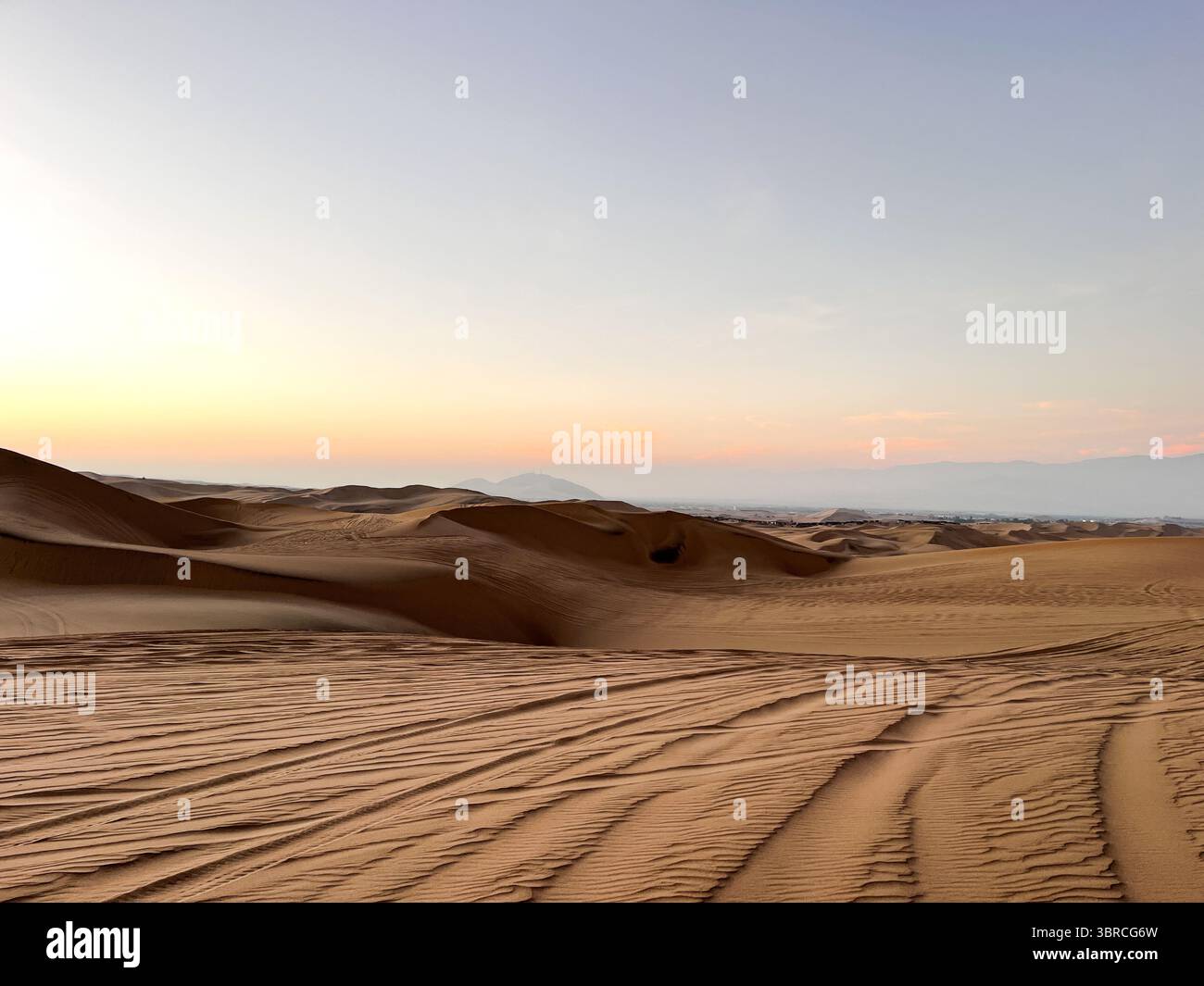 Vue sur les dunes de sable et fatigué fait par buggy voiture qui transporte les routes touristiques à travers des paysages arides dans la zone désertique de Huacachina, ICA, Pérou Banque D'Images