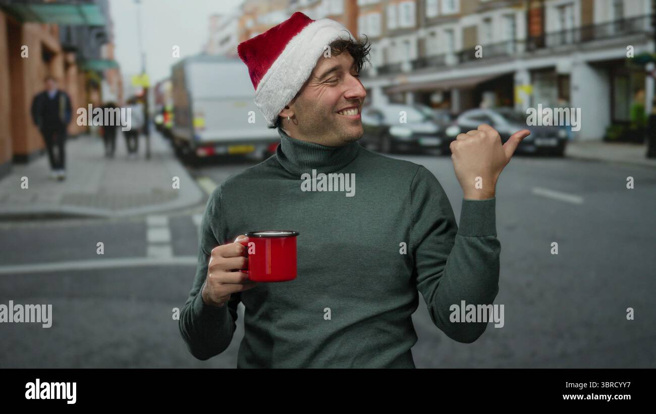 Homme hispanique portant un chapeau de noël tient une tasse rouge, souriant avec confiance dans une rue animée, avec des piétons flous et des voitures en arrière-plan, showc Banque D'Images