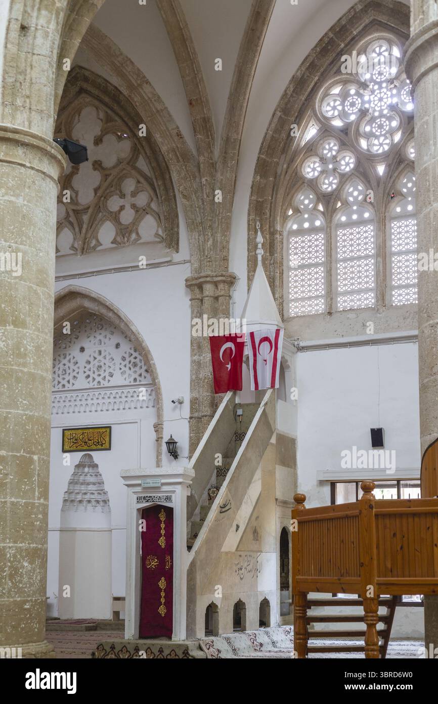 Varosha, Chypre - 25 juin 2025 : vue sur l'intérieur de la mosquée Lala Mustafa Pacha, où les piliers en pierre vieilles rencontrent les murs blancs modernes, ornés du Turki Banque D'Images